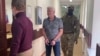 Russia-- In this handout photo taken from video released by Lefortovo District Court, Robert Shonov walks escorted by officers to the court room at the Lefortovo District Court in Moscow, Russia, Thursday, May 18, 2023. 