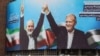 A woman walks amids vehicles next to a billboard of Iranian President Masoud Pezeshkian (R) and late Hamas leader Ismail Haniyeh at the Valise square in Tehran, on August 1, 2024.