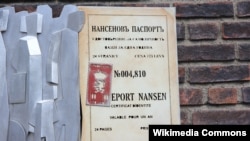 Памятник Нансеновскому паспорту на стене городской ратуши в Осло. Этот документ был разработан в 1922 году норвежцем Фритьофом Нансеном, комиссаром Лиги Наций по делам беженцев